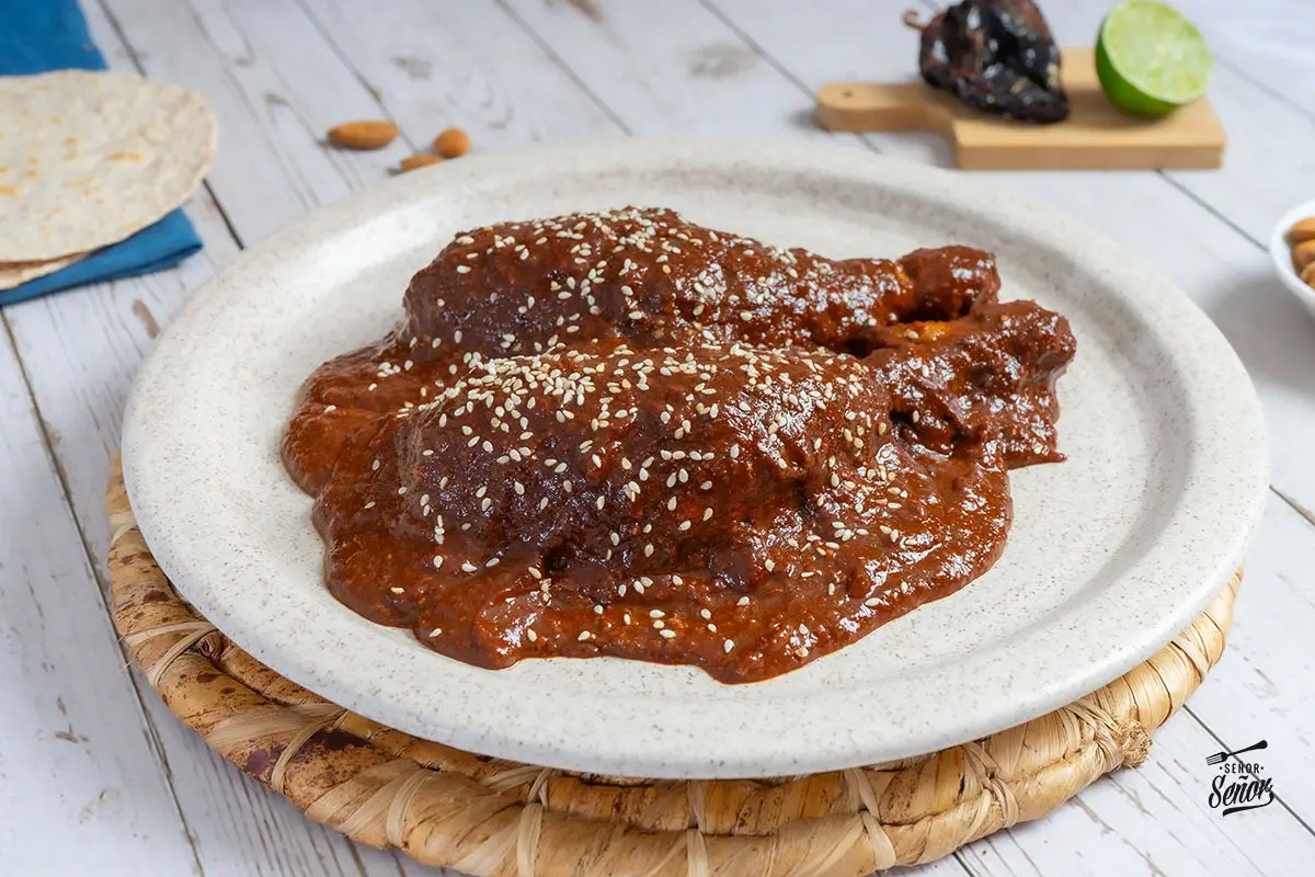 Tipos de cultura culinaria extrema: mole poblano tradicional con chiles ancho, pasilla y mulato sobre guajolote en cazuela de barro