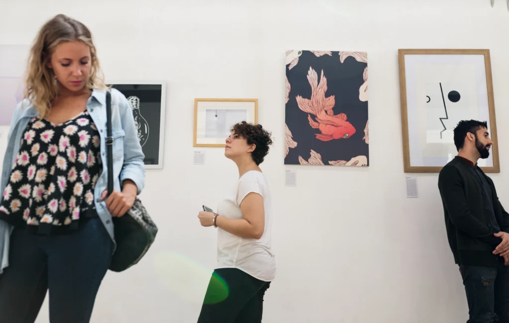 Personas mirando cuadros en una galería