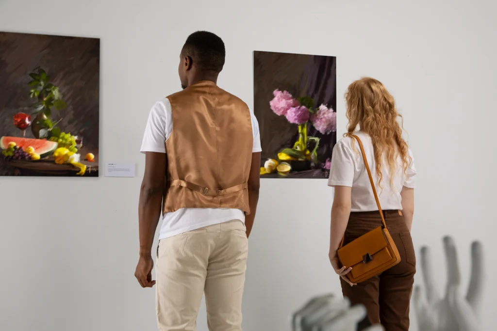 Un hombre y una mujer mirando cuadros en una galería de arte