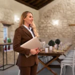 Persona organizadora de eventos con el evento organizado detrás