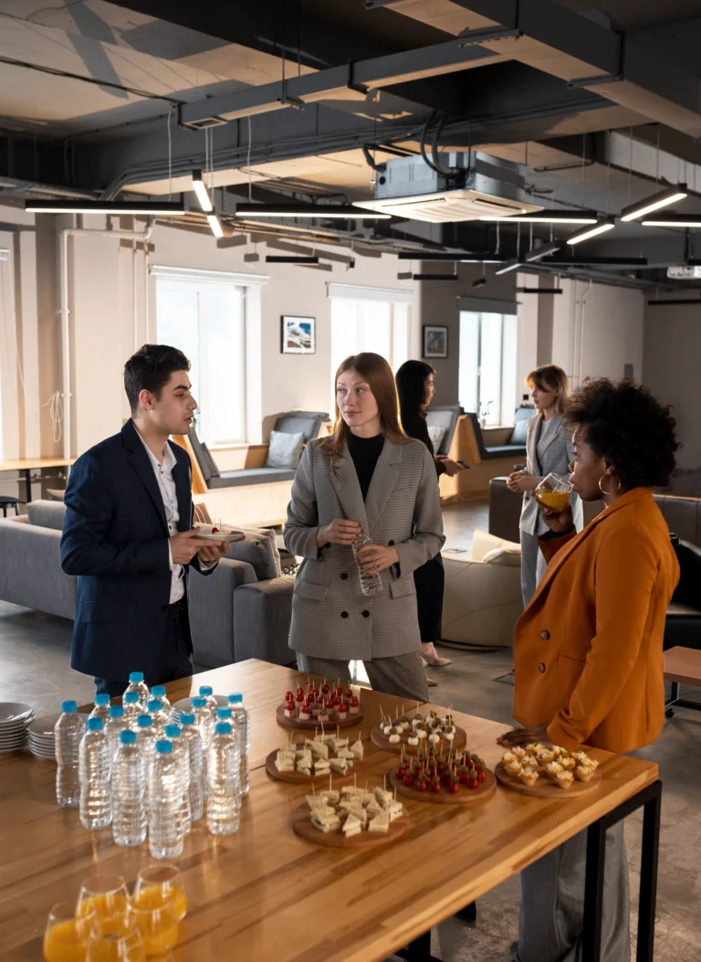 Personas en un evento y mesa con comida y agua