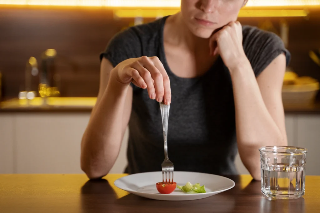 Mujer comiendo y pinchando con el tenedor un tomate