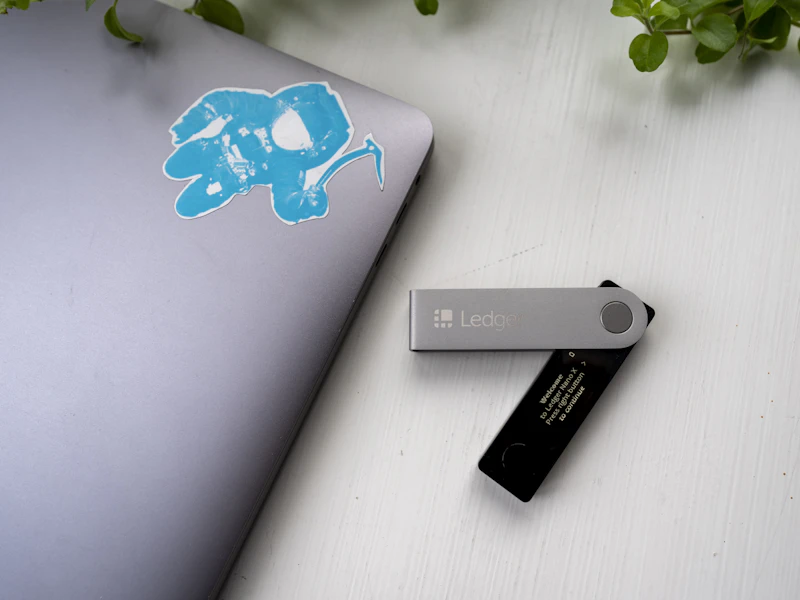 Cartera física para criptomonedas junto a un ordenador portátil sobre mesa