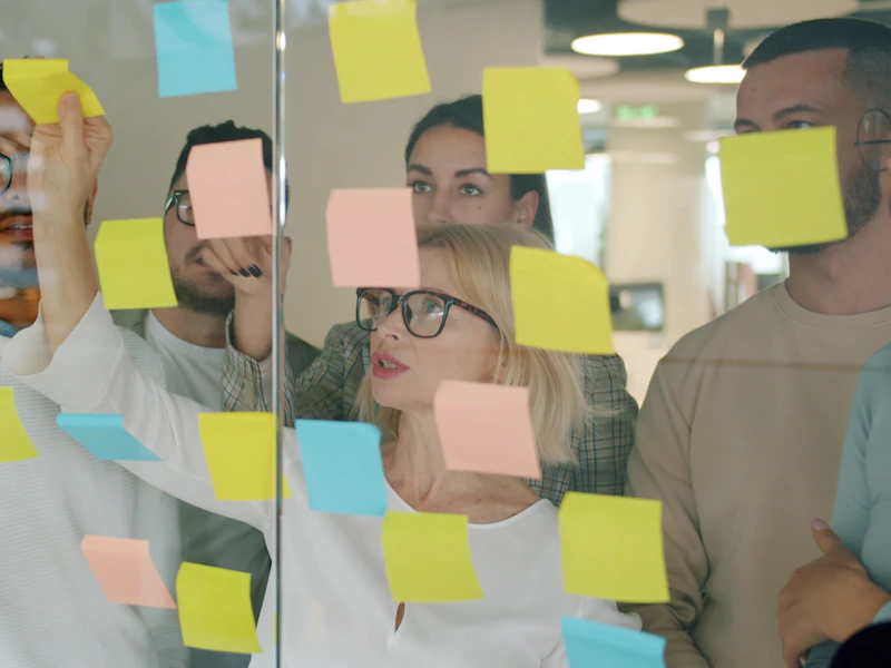 Equipo creativo analiza propuestas de mensajes comerciales junto a notas de colores