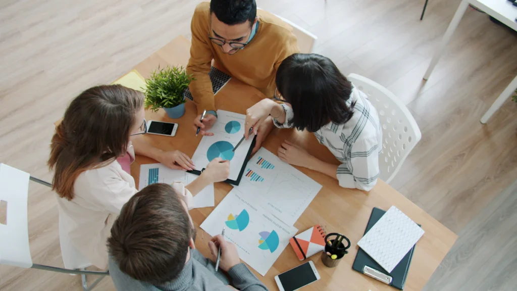 Equipo directivo revisando gráficos durante una sesión de gestión empresarial