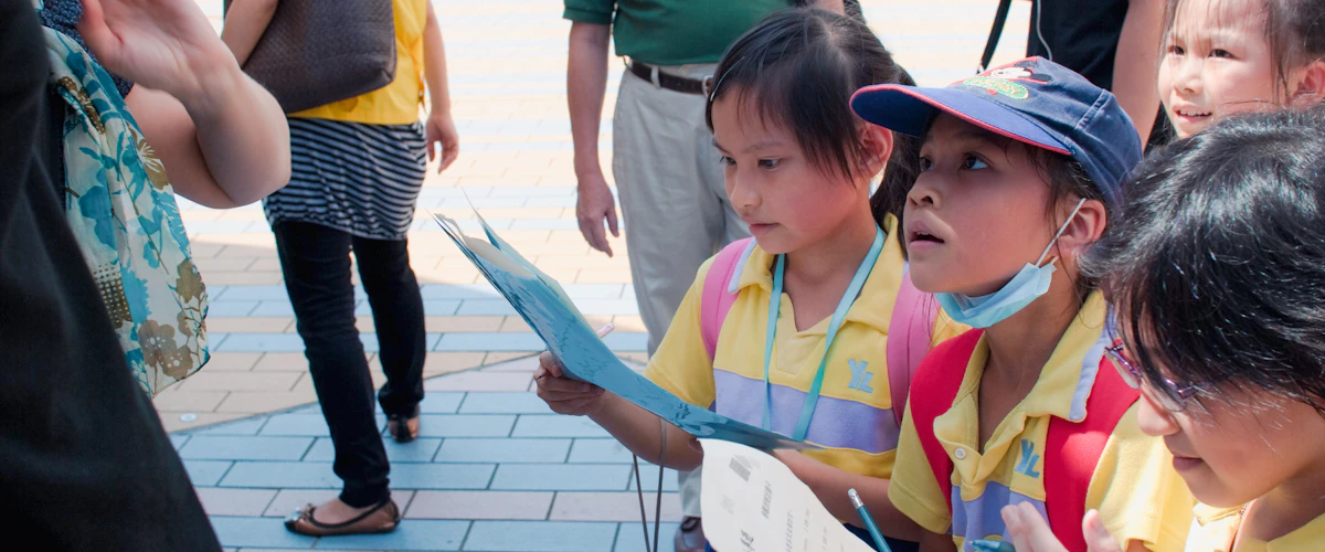 Escolares observan hojas de trabajo durante una actividad de exploración al aire libre