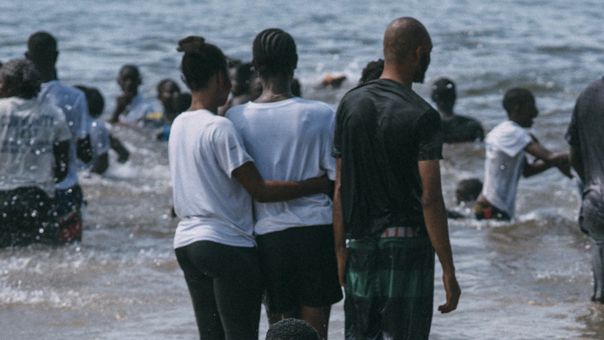 Grupo de voluntarios colaborando entre personas reunidas en una zona costera