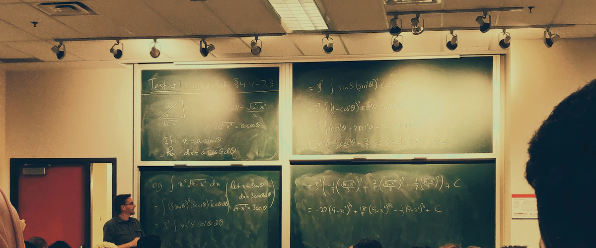 Personas sentadas en un aula universitaria frente a una pizarra