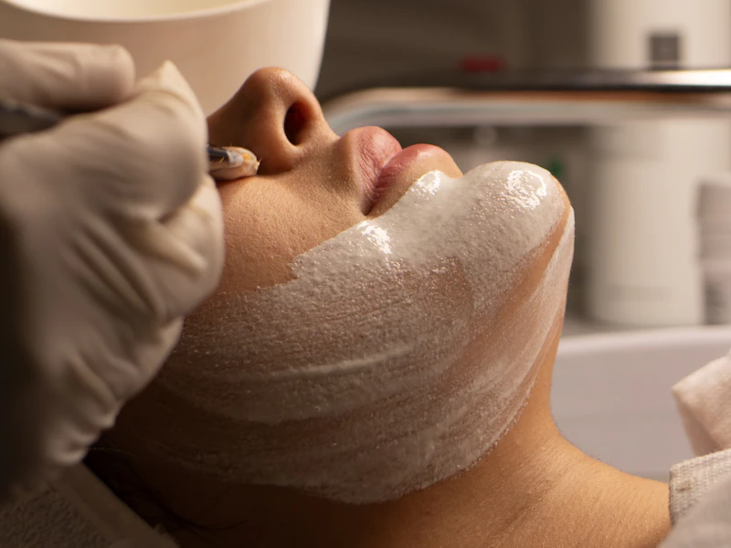 Profesional realizando una limpieza del rostro durante una sesión de cuidado facial