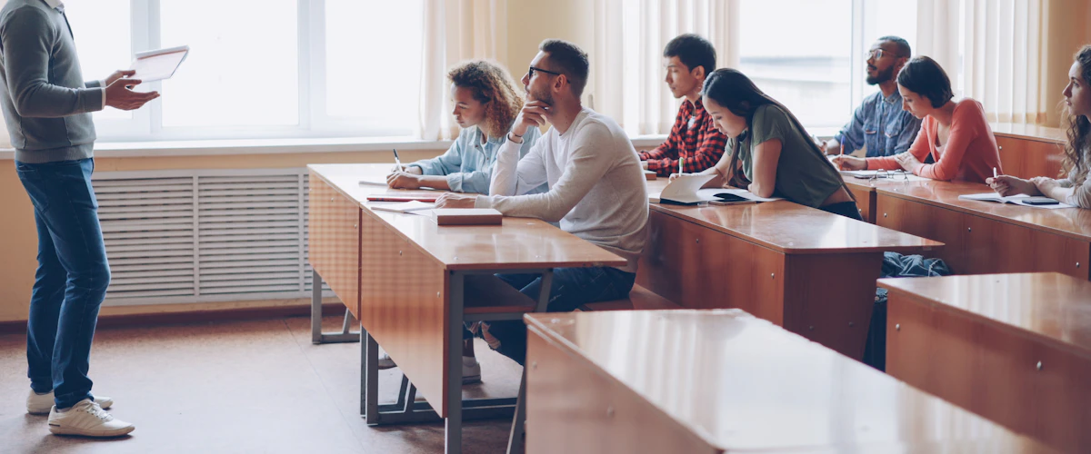 Profesor explica conceptos a estudiantes durante una clase universitaria