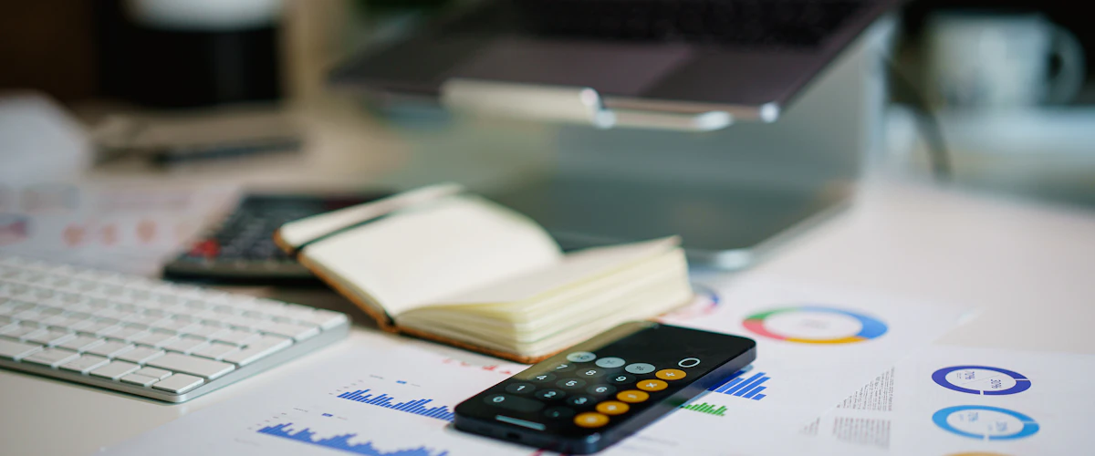 Teléfono inteligente junto a documentos financieros sobre una mesa de trabajo