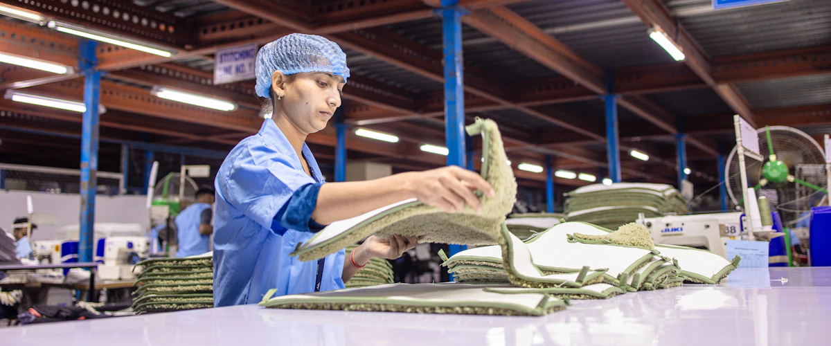 Un operario dobla piezas de tela en una instalación de confección industrial