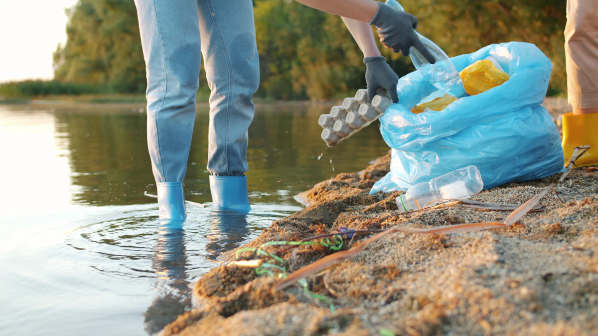 Voluntarias con guantes recogen residuos junto al cauce de un río