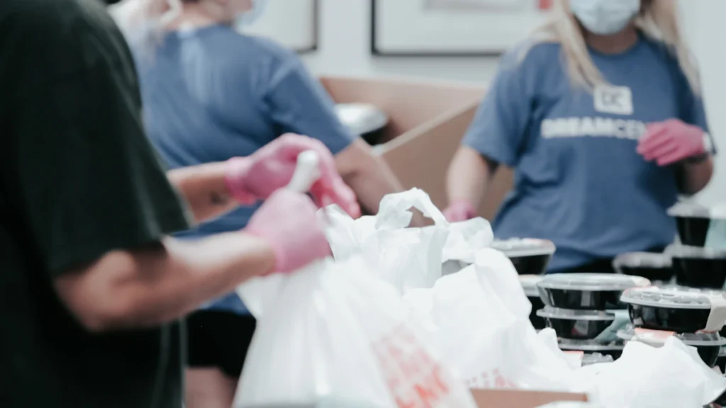 Voluntarios preparando bolsas de alimentos para distribuir ayuda humanitaria comunitaria